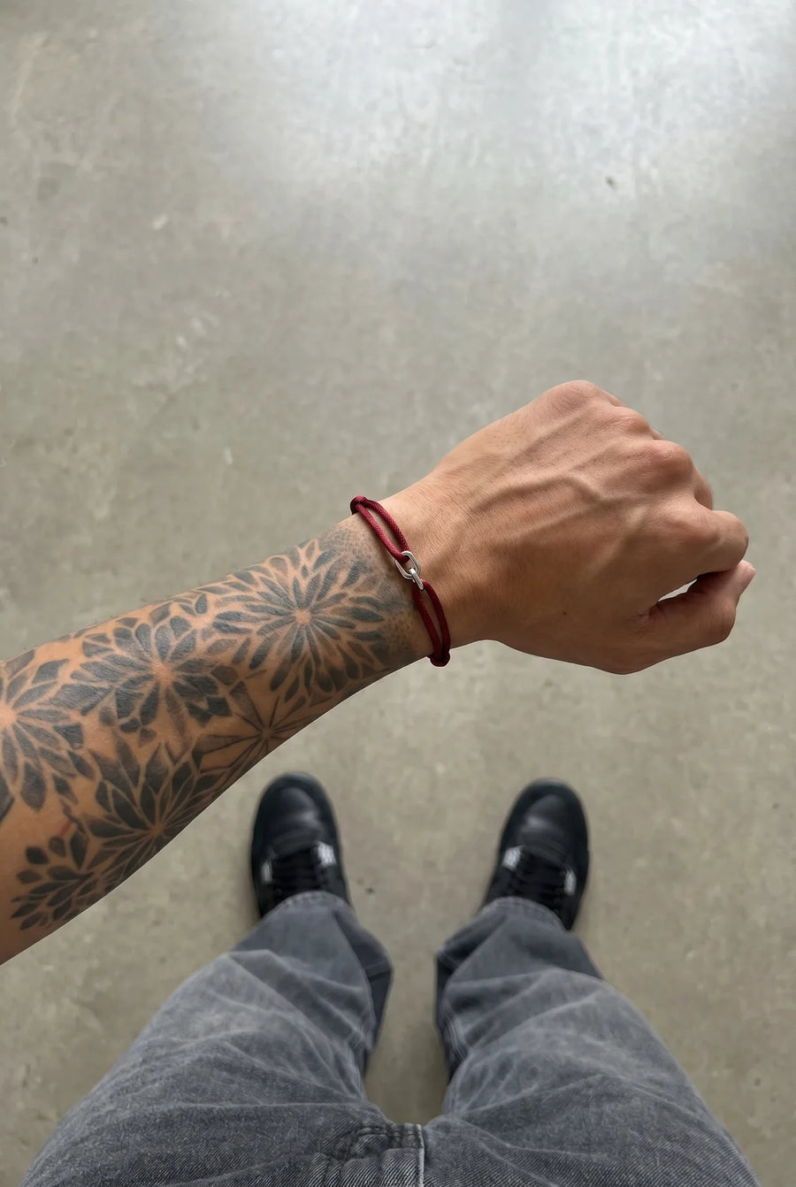 Tiefrotes 304supply Blood Link Armband am Handgelenk eines Mannes, POV