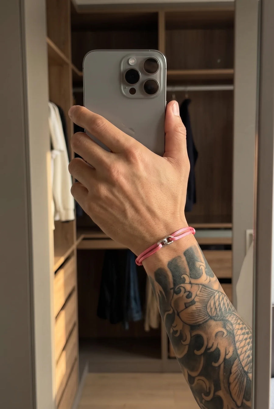 Hand mit dem rosé 304supply Blossom Link Cord-Armband im Streetwear-Look