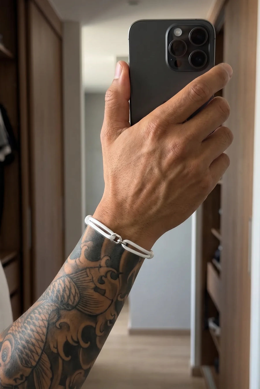 Hand mit dem weißen 304supply Snow Link Cord-Armband im Streetwear-Look