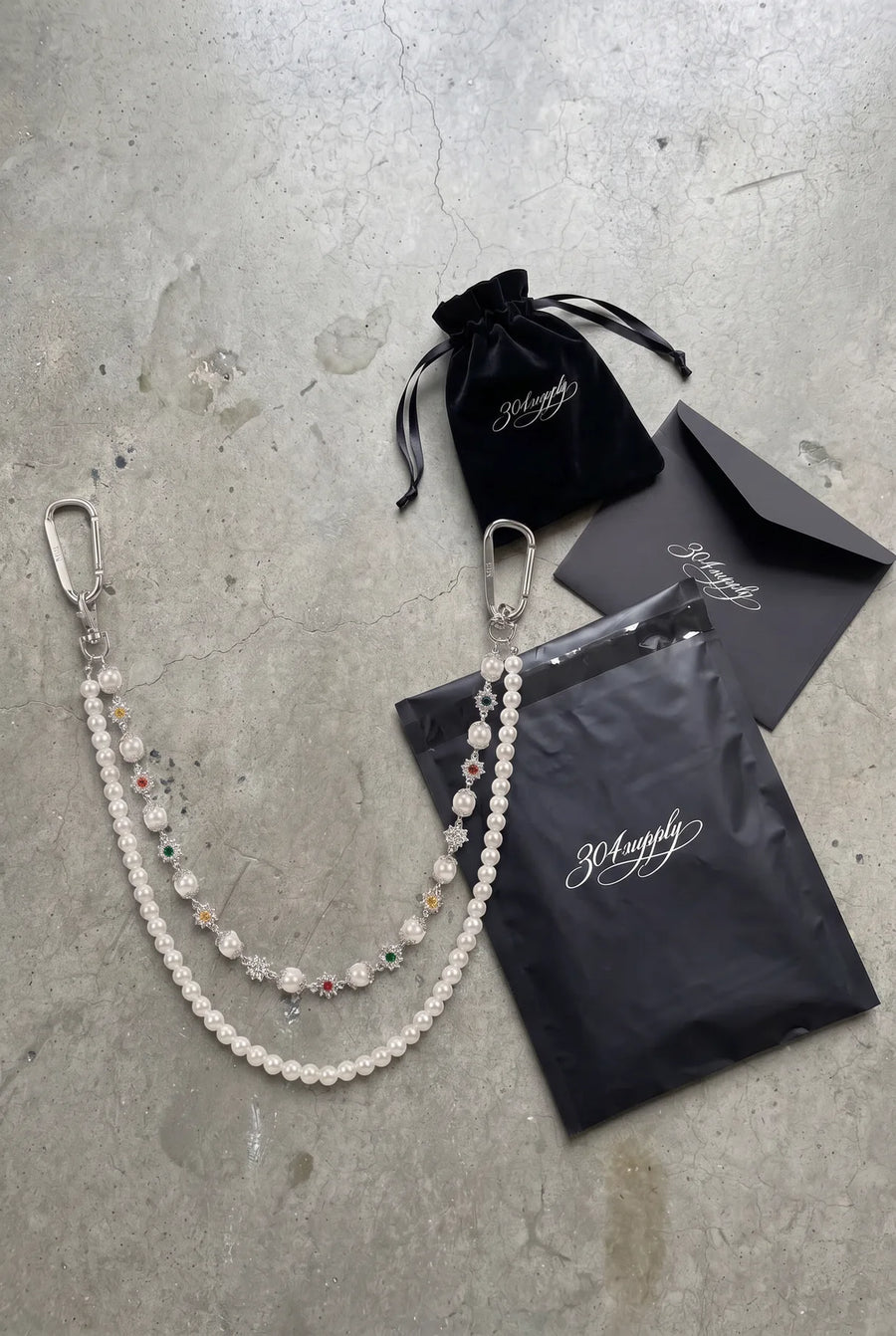 304supply Crystal Grace Wallet Chain aus Edelstahl als Flatlay mit Verpackung