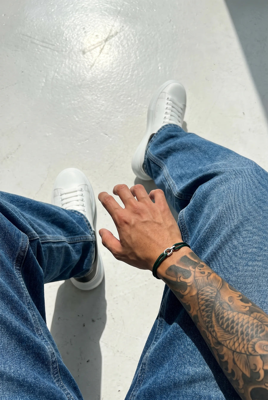 Hand mit dem tiefgrünen 304supply Forest Link Cord-Armband im Streetwear-Look