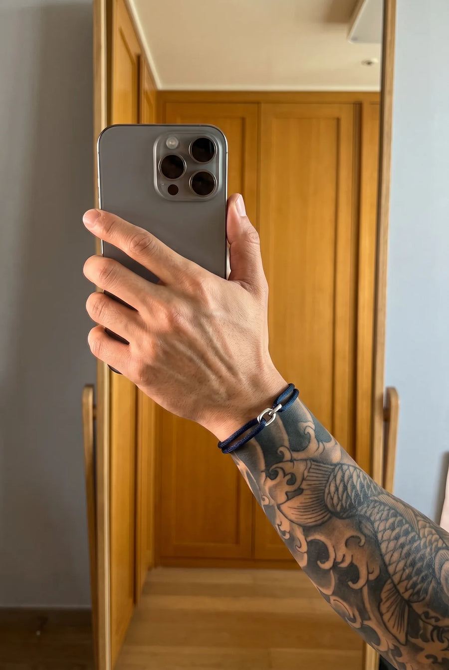 Hand mit dem dunkelblauen 304supply Midnight Link Cord-Armband im Streetwear-Look