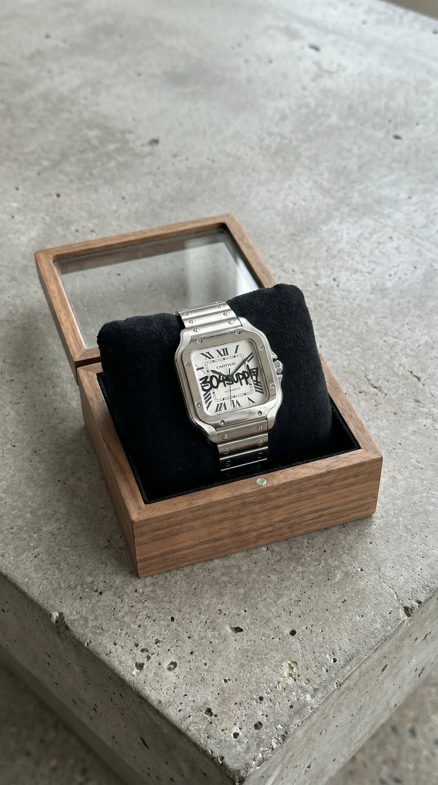 304 Santos Uhr in einer Uhren-Vitrine auf Beton, Collector-Look