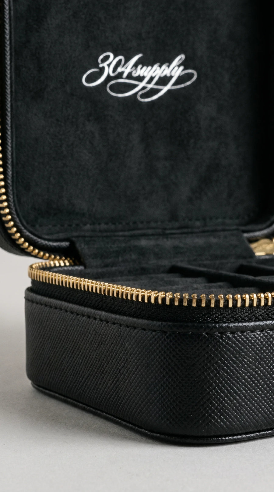Close-up des Gold-Reißverschlusses und 304supply-Logos der 304 Jewelry Box